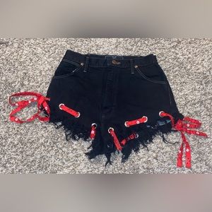 Black wrangler shorts with red bandana ribbon going though the bottom
